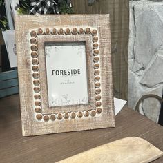 a wooden frame sitting on top of a table next to a cutting board and knife