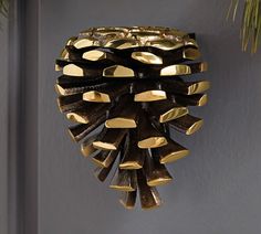 a gold pine cone hanging from the side of a wall