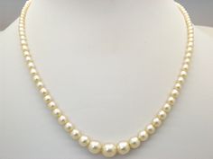 Hello and welcome to my shop.              I am offering to you this beautiful quality single row of vintage 1960's / 70's period faux pearl necklace. As you will see in the pictures the necklace is handmade in a single row of shiny polished graduated rich cream coloured faux pearl beads. The necklace clasp is a silver tone and diamante set push in type in good working order.  This fine single strand pearl necklace is in an excellent used vintage condition with just slight age related surface we Formal Single Strand Cream Pearl Necklace, Formal Cream Single Strand Pearl Necklace, Cream Single Strand Pearl Necklace, Classic Cream Necklaces With Round Beads, Formal Cream Beaded Necklaces, Formal Cream Beaded Necklace, Vintage Cream Single Strand Pearl Necklace, Six Photos, Classic Pearl Necklace