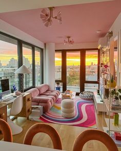 a living room filled with lots of furniture and large windows next to a cityscape