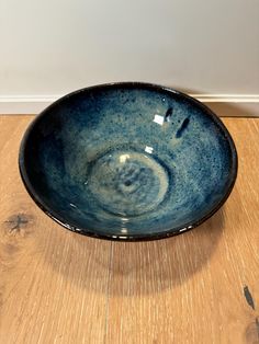 a blue bowl sitting on top of a wooden floor