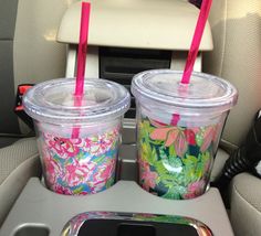 two plastic cups with straws sitting in the back seat of a car