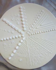 a white plate with beaded designs on it