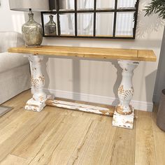 a wooden table sitting in the middle of a living room next to a white couch