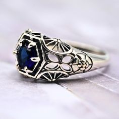 an antique style ring with a blue stone in the center