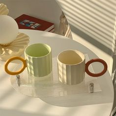 three coffee mugs sitting on top of a white table