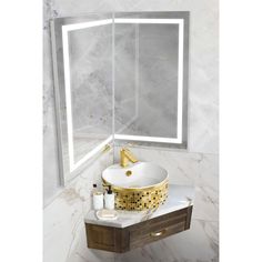 a bathroom sink sitting under a mirror in front of a wall mounted vanity with a gold faucet