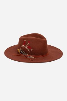 Crafted from 100% wool, the Hummingbird Heather Hat is available in an earthy rust color. Featuring a mid-height crown and a wide brim, this hat is finished with intricate placement embroidery and a decorative feather placed thoughtfully at the hatband. Style with a denim-on-denim look and western style boots for an eclectic ensemble. Johnny Was Women's Hummingbird Feather Hat in Rust Brown, Denim Western Wool Hat Band For Spring, Western Wool Hat Bands For Spring, Curved Brim Hats For Rodeo In Fall, Fall Fedora With Fur Felt And Flat Crown, Wool Fedora With Short Brim For Fall, Fall Wool Fedora With Short Brim, Fall Wool Fedora With Curved Brim, Fall Short Brim Fur Felt Hat, Fur Felt Fedora For Fall Rodeo