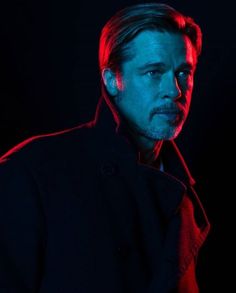 a man in a black coat looking at the camera with red light coming from his eyes