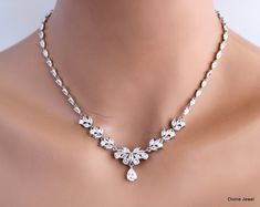 "bridal rhinestone necklace, bridal crystal necklace, wedding rhinestone necklace, bridal necklace, wedding necklace, statement necklace This statement necklace is made with cubic zirconia stones.  Crystals shape are marquise, teardrops, and round. It has rhodium finish chain to complete the rest of the length. Focal measures about 10 3/4\" long by 1 7/8\" in the middle including the teardrop.  Has the right amount of sparkle for your vintage inspired wedding or special occasion event.  This necklace can be made without the chain upon request.  Contact me happy to give you a quote. Perfect for a classy bride or any special occasion! ." White Bling Bridal Necklace For Wedding, White Bridal Necklace With Bling For Wedding, White Rhinestone Wedding Necklace With Sparkling Stones, White Sparkling Rhinestone Necklace For Wedding, Sparkling White Rhinestone Necklace For Wedding, Dazzling Rhinestone Wedding Necklaces, Dazzling White Rhinestone Necklace For Wedding, Glamorous Diamond White Rhinestone Necklace For Weddings, Crystal Bling Backdrop Necklace For Wedding