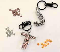 three different types of beads and charms on a white surface, one is shaped like a cross