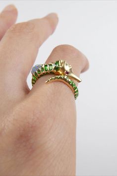 Green Seahorse Ring made of 18k gold, ruby and enamel from Lunar Rain. Designed by Melissa Chen. Unique Yellow Gold Enamel Ring For Anniversary, Unique Enamel Rings With Gemstone, Green Enamel Ring For Wedding, Unique Yellow Gold Snake Ring, Green 14k Gold Enamel Ring As Gift, Green Enamel 14k Gold Ring Gift, Unique Yellow Gold Enamel Ring For Formal Occasions, Yellow Gold Enamel Open Ring Jewelry, Unique Hallmarked Yellow Gold Emerald Ring