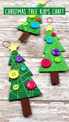 three christmas trees made out of paper with buttons and wooden pegs on the sides