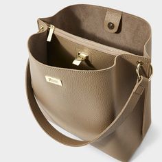 Our top-rated Reese Shoulder Bag in taupe is always a hit with your customers. The mixture of vegan leather design, gold-tone hardware, chic buckle fastening and sturdy shoulder strap secures this style as the ultimate everyday bag. Vegan Leather Height: 11" Depth: 5 15/16" Length: 11 7/16" Color: Taupe, Off White, Black Packaged and Shipped from Indianapolis, IN Copper And Grey, Taupe Colour, Everyday Bag, Leather Design, Vegan Leather, Leather Bag, Pu Leather, Shoulder Strap, Product Launch