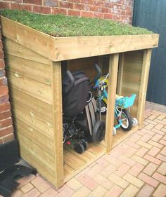 a bike is parked in a wooden shed with grass growing on the roof and side walls