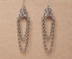 These delicate earrings are made from ornate antique silver filigree and 2 sets of chains. They will make a beautiful accessory for someone who loves the Gothic Victorian aesthetic. -The earrings are 2.75 inches long, without the lever back closure -They have a lever back closure SHIPPING: Default shipping is by regular mail, which does not have tracking, shipping times are as follows: US: 1-3 weeks Canada: 1-2 weeks Europe: 2-4 weeks If you would like to add tracking for your parcel, please upg Victorian Chandelier Earrings With Intricate Design, Victorian Chandelier Dangle Earrings With Intricate Design, Classic Filigree Dangle Chandelier Earrings, Classic Filigree Chandelier Dangle Earrings, Classic Filigree Chandelier Earrings, Classic Silver Chandelier Earrings For Pierced Ears, Classic Silver Chandelier Earrings, Antique Metal Chandelier Dangle Earrings, Antique Metal Drop Chandelier Earrings