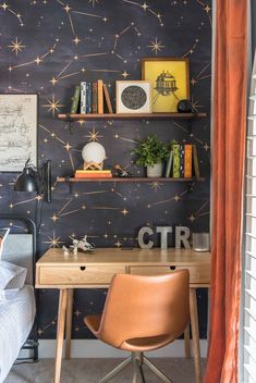 a bedroom with a desk, bookshelf and space themed wallpaper on the walls