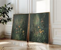 two paintings are sitting on the floor next to a potted plant in front of them