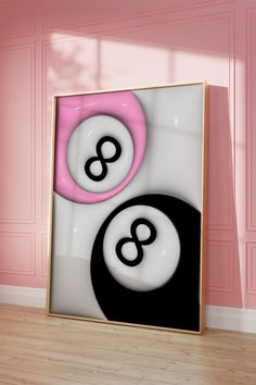 an abstract painting with two black and white circles in front of a pink wall behind it