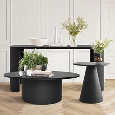 two black tables with plants and books on them