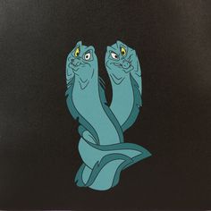 two blue cats sitting next to each other on top of a black surface with yellow eyes