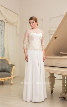 a woman standing in front of a piano wearing a long white dress with sheer sleeves