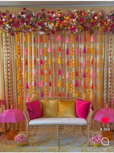 a decorated room with pink and yellow decorations on the wall, two chairs and a couch