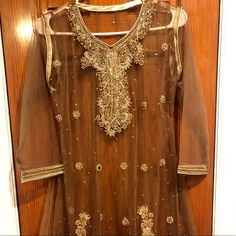 Bronze/Brown Frock With Gold Stone Work. 4 Piece Suit. Shiny-Material Lining With Beaded Work On Transparent Top. Pants Are A Lil Over 36 Inches. Top Is 40 Inches. Undershirt Is 38 Inches. Dupatta Is Brown Net With Minimum Beadwork. Never Worn. Brand New! Brown Anarkali Dress For Festive Occasions, Brown Wedding Dress With Dupatta, Traditional Brown Dress With Dupatta, Fitted Brown Anarkali Dress, Festive Brown Anarkali Dress, Traditional Brown Formal Dress, Brown Dress With Dupatta For Festive Occasions, Elegant Brown Dress With Dupatta, Elegant Brown Party Sets