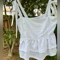 Beautiful Bright White Sun Blouse With Tie-Up’s For Sleeves. Peplum. The Peplum Ruffles Are Sheer But The Breast/Top Area Fully Lined. Beautiful Embroidery Detail All Over. Never Worn Bought At Nordstrom. Casual Smocked Top With Tie Straps For Spring, Summer Cotton Blouse With Smocked Bodice, White Cotton Peplum Top With Ruffles, Feminine Summer Top With Smocked Back, Summer Feminine Top With Smocked Back, Feminine Summer Tops With Smocked Back, Spring Brunch Tops With Tie Straps, Summer Flowy Blouse With Smocked Bodice, Spring Vacation Tops With Tie Straps