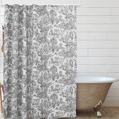 a bathroom with a bathtub, shower curtain and white brick wall in the background