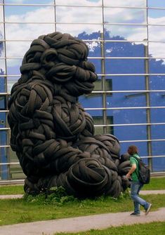 a person walking past a giant sculpture in front of a building