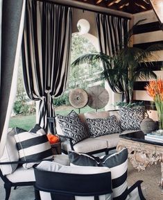 the living room is decorated in black and white striped furniture, with palm trees on either side