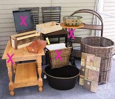 several baskets and other items are sitting on the porch floor next to a table with a basket