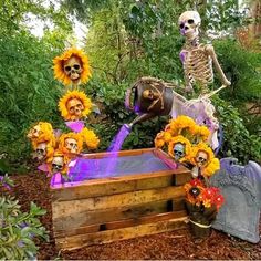 skeletons and sunflowers decorate an outdoor fountain for the day of the dead celebration