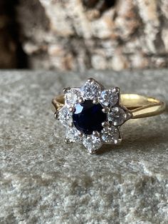 A wonderful vintage 18ct Gold Natural Sapphire And Diamond Cluster ring , eight gorgeous bright sparkling Brilliant Cut Diamonds approximately 2.5mm, totalling approximately 50pts or half a carat surrounding a stunning deep blue Sapphire 5mm in diameter approximately 65pts or over half a carat ,  classic flower design cluster, hallmarked in London 1986, Size l or US 5.5 Classic 14k Gold Cluster Diamond Ring, Dazzling Yellow Gold Sapphire Ring With Brilliant Cut, Classic Diamond Cut Cluster Ring, Classic Round Diamond Cut Cluster Ring, Classic Sapphire Ring With Vvs Clarity Cubic Zirconia, Classic Round Cluster Ring With Diamond Cut, Classic Round Cluster Ring With Vvs Clarity, Classic Cluster Sapphire Diamond Ring, Classic Sapphire Cluster Diamond Ring