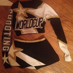 a cheerleader uniform is laying on the floor in front of a wooden floor with white and black stripes