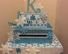 a three tiered cake decorated with snowflakes and icing