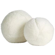 two white fluffy balls sitting next to each other on a white surface with one ball in the middle