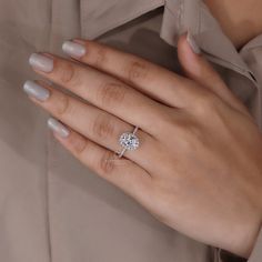 a woman's hand wearing a diamond ring