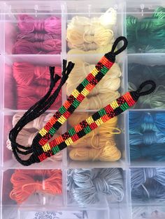 many different colors of yarn in plastic containers