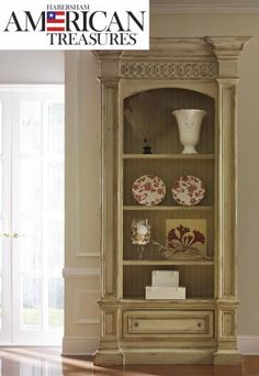 an antique china cabinet with plates and vases on it