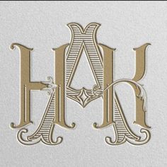 the letter h is made up of gold and silver foil with an intricate design on it