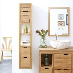 a bathroom with a sink, mirror and wooden cabinet in the corner next to it