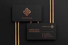 two black business cards with gold foil on the front and back, sitting next to each other