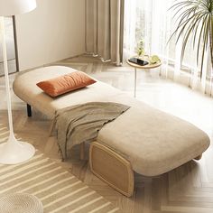 a bed sitting on top of a hard wood floor next to a table with a lamp