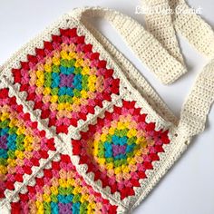 a crocheted granny bag is shown on a white surface with the handles down