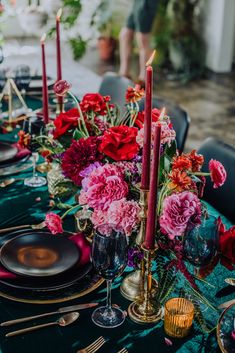 the table is set with flowers and candles