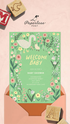 a welcome baby card with rubber stamps in an envelope and flowers on the inside, along with two wooden blocks