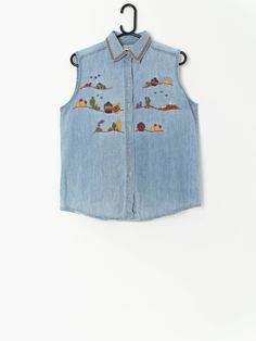 90s denim vest with Mexican inspired embroidery. The vest is in a light blue denim with colourful and vibrant embroidery of horses, moon, stars, cactus, sun, mountain and pots. A really cute shirt to wear for a western look with some cowboy boots! Our recommended size: Medium to large  Label says: Large  Condition: Very good  Material: 100% cotton  Measurements in inches: Pit to pit: 20 Shoulders: 14 Front length: 25 Back length: 25.5 We've provided garment measurements and we recommend that you Summer Blue Denim Vest, Sleeveless Denim Vest For Festivals, Bohemian Sleeveless Denim Vest For Summer, Blue Embroidered Denim Vest, Denim Blue Cotton Vest For Summer, Bohemian Medium Wash Denim Vest For Summer, Blue Bohemian Denim Vest For Spring, Bohemian Blue Denim Vest For Spring, Summer Embroidered Blue Denim Vest