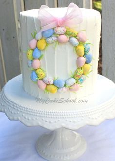 a white cake decorated with an egg wreath